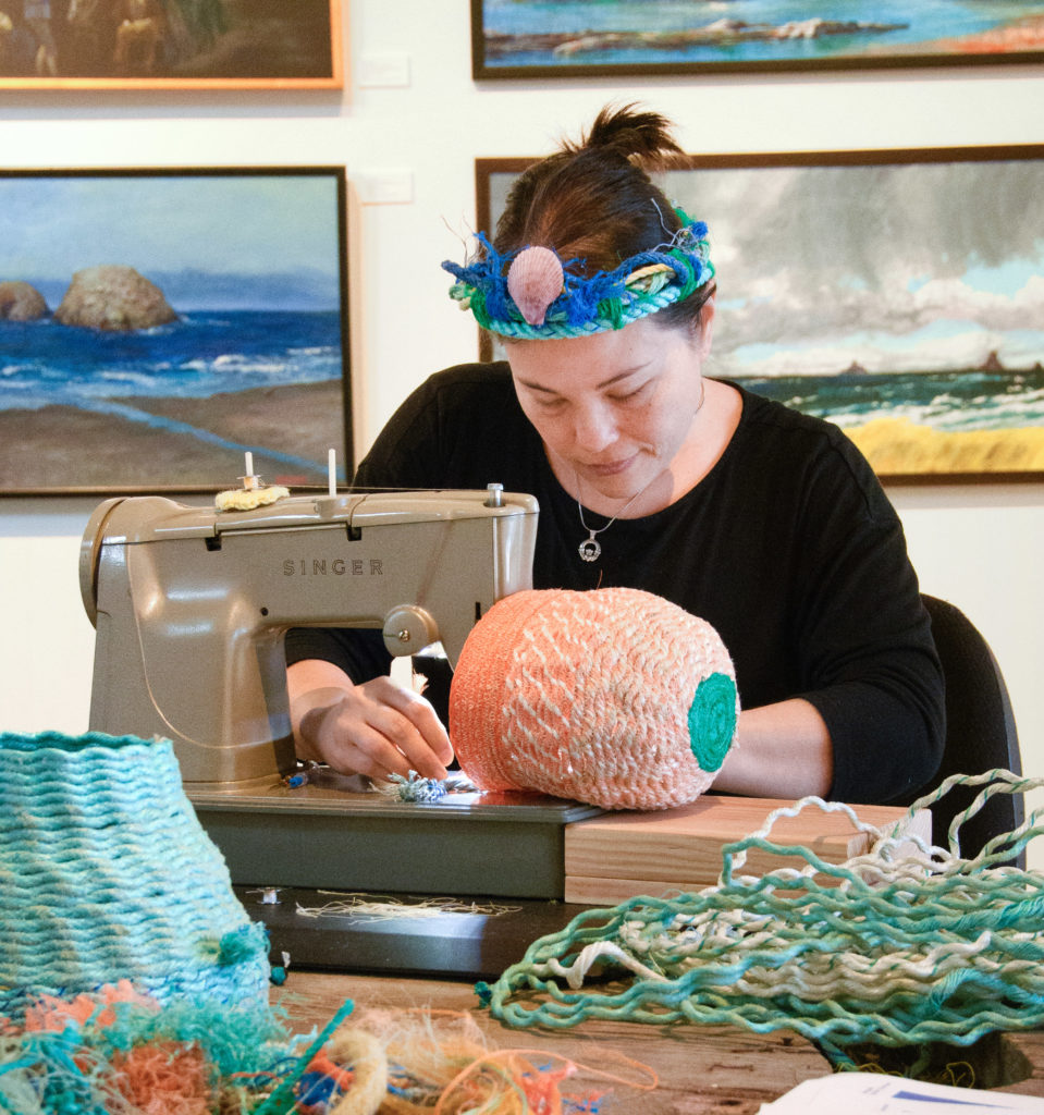 Emily stitching ghost net baskets at Elisabeth Jones Art Center